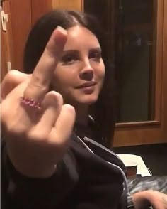 a woman making the peace sign with her fingers