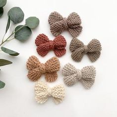 four crocheted bows with leaves in the background