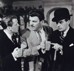 three men in suits and hats talking to each other