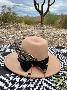 This tan felt hat is complimented with a rugged black band and a rust leather tie. It is accented with brass and carved bone beads and a turkey feather and dried olive leaves.  Wander in the desert. Rustic Adjustable Felt Hat For Festival, Bohemian Felt Hat For Western-themed Fall Events, Rustic Brown Hat Bands For Fall, Adjustable Feather Hat Bands For Fall, Southwestern Brown Feather Hat Bands, Southwestern Brown Felt Hat For Western-themed Events, Southwestern Brown Hat Bands With Feathers, Western Brown Hat Band With Feather Trim, Western Brown Hat Bands With Feather Trim