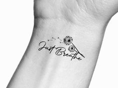 a dandelion tattoo on the wrist saying just breathe