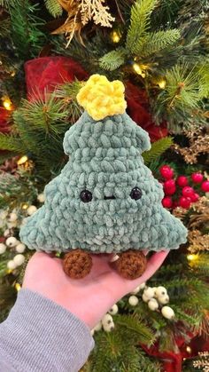 someone is holding up a crocheted christmas tree ornament in their hand