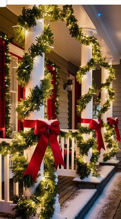 christmas wreaths on the front porch decorated with red ribbon and lights for holiday decor