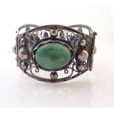 Up for sale is a Vintage Mexico Jade Cabochon Sterling Silver Repousse Filigree Bracelet. Bracelet measures approx. 6 3/4" by 1 5/8" wide. Weighs 61.6 grams. Jade stones measure approx. 1" by 3/4" each. Sterling will polish nicely. Nice vintage condition. Comes exactly as shown. Please ask any questions before buying.  I Vintage Green Cuff Bracelet For Formal Events, Vintage Cabochon Bracelets For Formal Occasions, Vintage Green Cuff Bracelet For Formal Occasions, Green Vintage Cuff Bracelet For Formal Occasions, Vintage Cabochon Bangle Jewelry, Green Vintage Formal Cuff Bracelet, Silver Cabochon Cuff Bracelet In Vintage Style, Vintage Cabochon Bangle Bracelets, Antique Silver Cabochon Bracelets