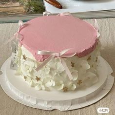 a pink and white cake with flowers on the top is ready to be cut into pieces