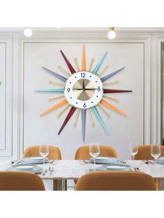 a large clock mounted to the side of a wall above a dining room table with yellow chairs