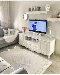 a living room filled with furniture and a flat screen tv on top of a white table