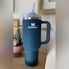 a blue travel mug sitting on top of a wooden table