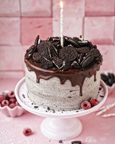 a birthday cake with oreo cookies on top and a lit candle in the middle