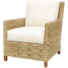 a wicker chair with a white cushion on top of the armrests and legs