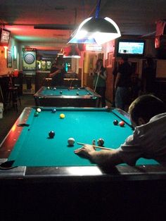 a man is playing pool in a bar