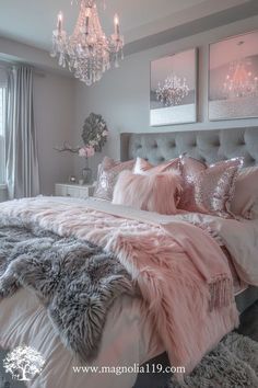 a bedroom with pink and grey decor, chandelier, bedding and pillows