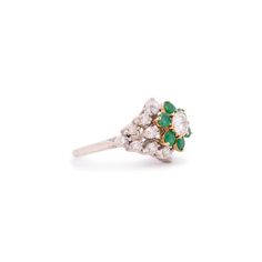 Gender: Ladies    Metal Type: 14K White & Yellow Gold    Size (US):    Width: Approximately 15.00mm tapering to 1.80mm    Diameter: 21.80mm    Weight: 5.16 Grams  This beautiful diamond cocktail ring is accented with 6 natural round emeralds with a half round shank.  Engraved with "14K".  Pre-owned in excellent condition. Might show minor signs of wear.    Prong Set in 14 Karat Yellow Gold with:    One (1) round brilliant cut natural diamond:    Measurements: 5.10mm - 5.20mm in diameter x ~3.14mm in depth.  Estimated Weight: 0.51 ct.  Color: G - H  Clarity: VS1 - VS2  Cut: Very Good  Polish: Very Good  Symmetry: Good    Prong Set in 14 Karat Yellow Gold with:    Six (6) natural, round-shaped, brilliant cut, emeralds:    Species: Natural Beryl  Variety: Natural Emerald  Measurements: 2.80mm Cluster Diamond Emerald Ring, Cluster Emerald Ring With Diamond Center Stone, Emerald Cluster Ring With Brilliant Cut Diamonds, Cluster Emerald Ring With Diamond, Emerald Cluster Diamond Ring With Center Stone, Cluster Emerald Diamond Ring With Center Stone, Luxury Vintage Green Cluster Ring, Antique White Luxury Cluster Ring, Emerald-cut Cubic Zirconia Cluster Ring In Fine Jewelry Style