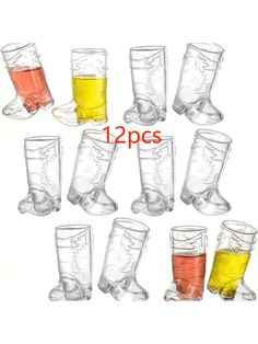 twelve glasses filled with different colored liquids on top of each other and one is empty