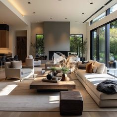 a living room with couches, chairs and tables in front of large glass windows