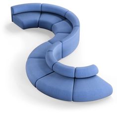 a blue curved couch sitting on top of a white floor