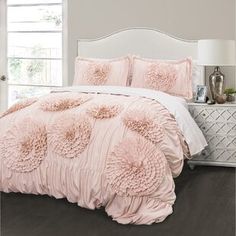 a bed with pink comforters and pillows in a room