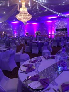 a banquet room with purple lighting and white linens