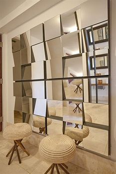 an image of a mirror in the middle of a room with stools and mirrors