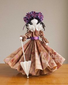 an origami doll is standing on a table