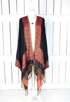 Handmade black and orange border paisley pashmina kimono cover up jacket with custom regular and maxi lengths and optional fringe detail Measurements...taken flat - width across seam to seam: 46"  - regular length with fringe: 38"  - regular length without fringe: 34"  - Maxi length is as selected with or without fringe Features... - lovely soft woven medium weigh pashmina fabric - bohemian oversized flowing design - cardigan style with an open front and generous arm holes  - universal design al Black Bohemian Shawl For Fall, Black One Size Bohemian Wrap, One Size Black Bohemian Wrap, Bohemian Black Wrap One Size, Black Bohemian Wraps One Size, Fall Shawl With Tassels, Fall Tassel Shawl, Festival Black Shawl Kimono, Black Bohemian Shawl For Spring