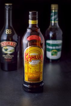 three bottles of beer sitting on top of a black counter next to each other,