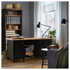 an office with a desk, chair and bookshelf in front of a window