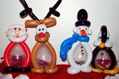 three snowman and two reindeer figurines sitting next to each other on a red blanket