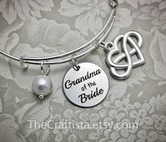 "♥ ✿ ♥ This elegant piece of jewelry will make a beautiful and sentimental gift that will best express your gratitude and love for your grandma. ♥ ✿ ♥ ✿ This piece includes ✿ ♥ disc pendant 20mm engraved with the words \"Grandma of the Bride\" ♥ infinity heart charm that symbolizes \"I love you forever\" ♥ authentic shell pearl (8mm) ♥ adjustable bangle 60mm in size (expandable to fit wrist 7-8\") ✿ Optional necklace (18-inch) OR keychain ✿ Leave a clear instruction at note to seller if you want Customized Silver Jewelry For Bridesmaid Gift, Adjustable Hallmark Jewelry For Gifts, Customized Jewelry For Bridesmaid Gift On Mother’s Day, Customized Jewelry For Bridesmaid Gift On Mother's Day, Customizable Adjustable Jewelry Gift For Mom, Customizable Adjustable Jewelry As Gift For Mom, Spiritual Charm Bracelet For Mother's Day Gift, Adjustable Customizable Jewelry, Mother's Day Gift Bangle Jewelry For Mom