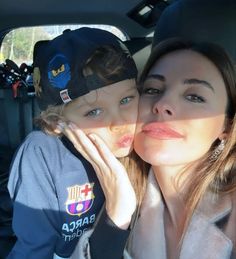 a woman and child are sitting in the back seat of a car with their heads together