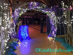 an archway decorated with lights and streamers in the middle of a dancefloor