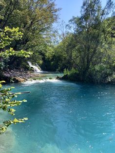 a river with blue water surrounded by trees