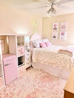 a bedroom with a bed, dressers and pink decor on the walls is shown