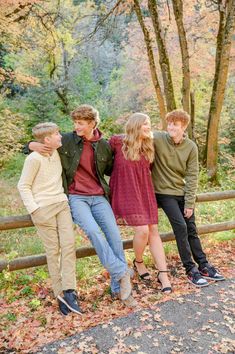 a family poses on a fence in the fall