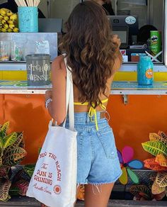 a woman standing in front of a food truck with her back turned to the camera