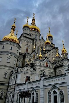 an ornate white and gold building with golden domes