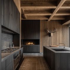 a kitchen with wooden walls and flooring next to a fireplace