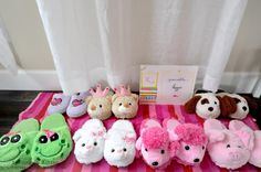 several stuffed animals are lined up on a pink and white striped tablecloth next to a card