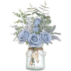 a glass vase filled with blue flowers and greenery