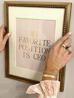 a woman's hands holding up a framed poster