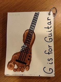 a guitar keychain with an image of a hand holding a ukulele