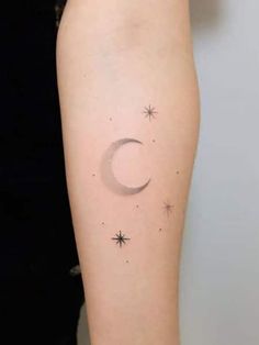 a small crescent and stars tattoo on the arm