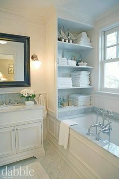 a bath room with a tub a sink and a mirror