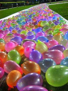 there are many balloons in the grass with words above them that say, have a water balloon ship and slide together