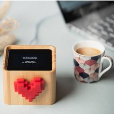 an electronic device with a heart on it next to a cup of coffee