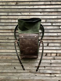 "This medium size backpack is made from waxed canvas in the color olive green with an outside pocket made in British waxed canvas color burned umber, with a layer of leather in front of the pocket. I made it into an everyday backpack/rucksack, with waxed canvas padded straps. Roll to close top, and outside pocket with protective flap. The bottom is made in oiled leather in the color brown. The bag closes with roll to close system and buckle and strap on the front in X-design made from vegetable Waxed Canvas Backpack With Leather Handles, Rugged Leather Backpack With Canvas Lining, Brown Waxed Canvas Leather Backpack With Leather Patch, Rugged Brown Waxed Canvas Backpack, Waxed Canvas Leather Backpack With Canvas Lining, Khaki Leather Backpack For Outdoor Activities, Rugged Canvas Leather Backpack With Leather Handles, Rugged Canvas Backpack With Leather Handles, Leather Backpack With Canvas Lining For Adventure