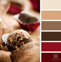 some chocolates are in a wrapper on top of a table with red and brown colors