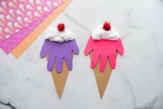 two ice cream cones with pink and purple paper on them