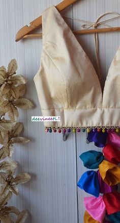 This Made to Order/Made to Measurement/Custom Made Indian Ethnic Blouse. - Fabric - Raw Silk - Color - Cream - Princess Cut - Padded - Plunging Neckline - Back Hook Closure - Dori on the shoulder with Multicolor Fabric Tassels - Sleeveless - Multicolor Ghungroo around the waist Fabric Care : Dry Clean Only Disclaimer: The actual color of the product might slightly differ from the image due to photographic lighting or monitor's display Shipping: This is made to order product. Once you place the o Festive Multicolor V-neck Blouse Piece, Multicolor V-neck Choli For Festive Occasions, Bohemian V-neck Unstitched Choli, Festive Bohemian V-neck Blouse Piece, Festive Bohemian V-neck Choli, Bohemian Cutdana Blouse For Party, Bollywood Style Blouse Piece With Latkans For Festivals, Festive Blouse Piece With Latkans For Navratri, Fitted Festival Blouse With Traditional Drape