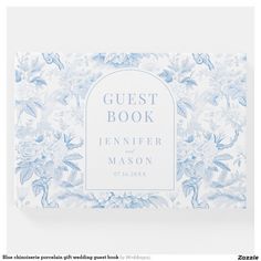 a blue and white wedding guest book with flowers on the cover, in front of a white background